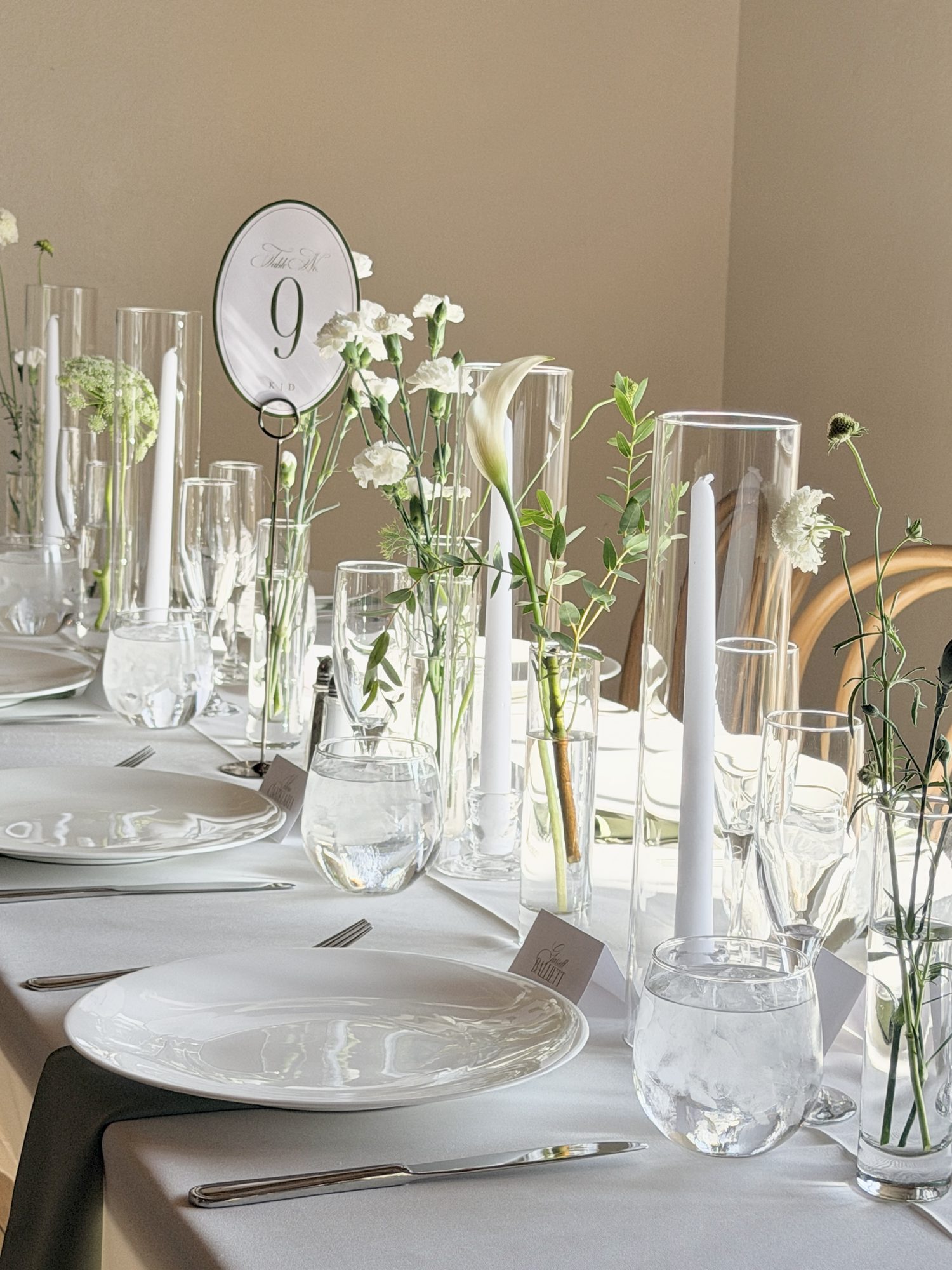 Table number nine with candles, carnations, and calla lily