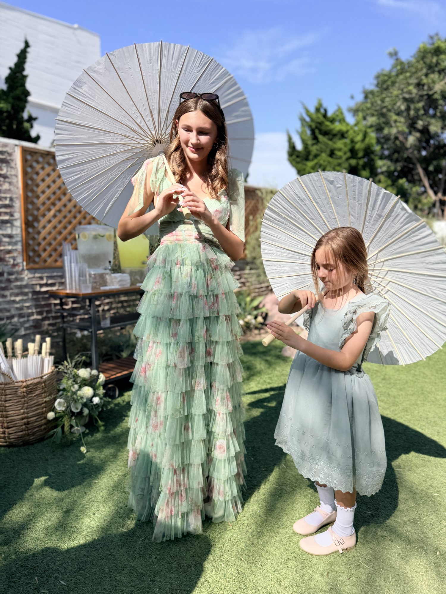 Flower girls with parasols at reception