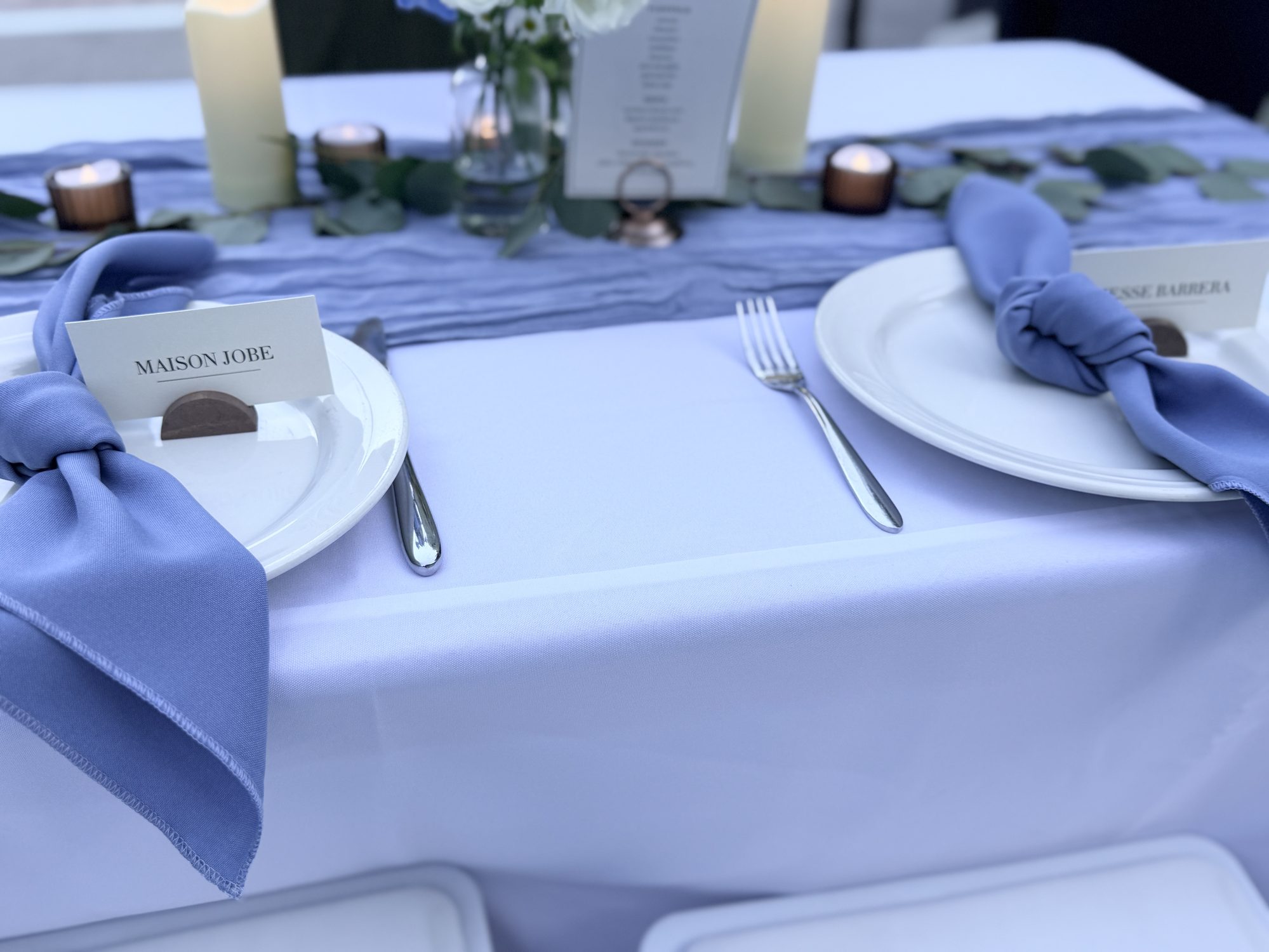 Reception table setting with blue napkins and place card